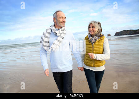 Cheerful senior people walking on the beach Stock Photo