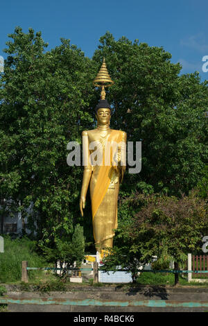 A large, gold standing Buddha sculpture in Hat Yai, Thailand. Stock Photo