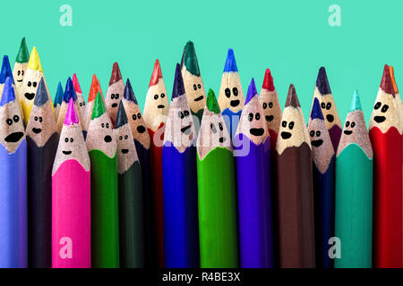 colored pencils with drawn cartoon faces, on an azure background, a holiday concept or a party Stock Photo