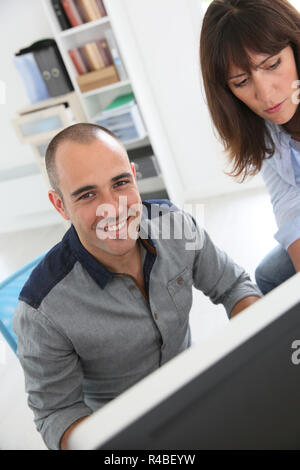 Workmates working on desktop computer Stock Photo