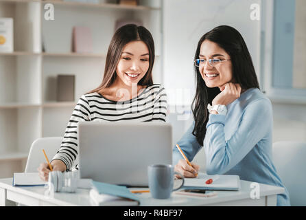 Interior designers. Two appealing pleasant skillful interior designers feeling creative while working on new project Stock Photo