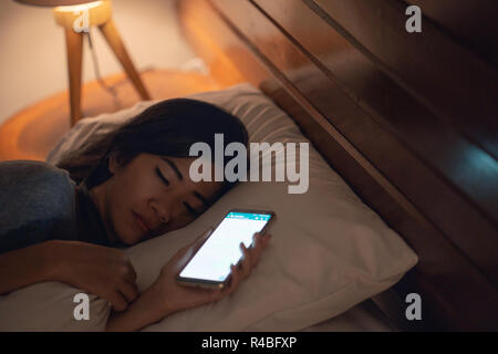 woman fell asleep after using mobile phone Stock Photo