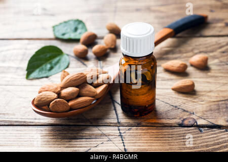Almond oil in bottle on wooden background. Concept Spa, aromatherapy and medicine Stock Photo