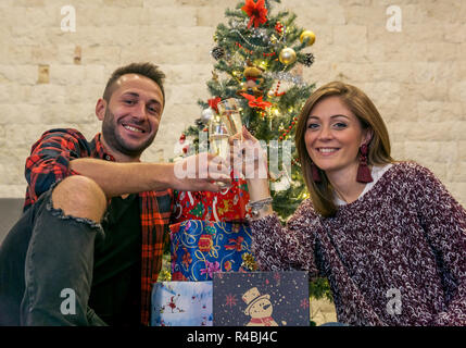 Happy and smiling friends toast under the christmas tree Stock Photo