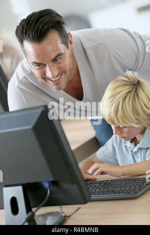 Schoolboy in computer lab with teacher helping Stock Photo - Alamy