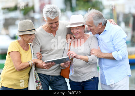 Senior tourists using tablet on visiting journey Stock Photo
