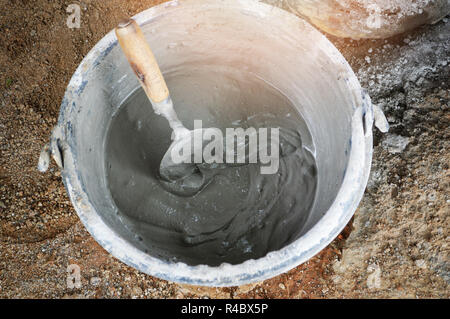 trowel used for work construction /  bucket with trowel stir until mixed cement concrete glue for floor and installing brick on the construction site Stock Photo