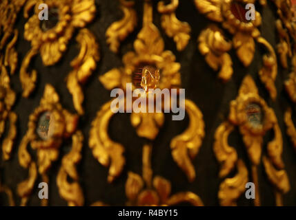 Closed Up the Face of Golden Buddha Image Reflecting on the Mirror of Teak Lacquered Pillar in Wat Phumin Temple, Historic Place in Nan, Thailand Stock Photo