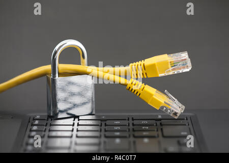Internet security concept. Padlock with internet cables on computer keyboard Stock Photo