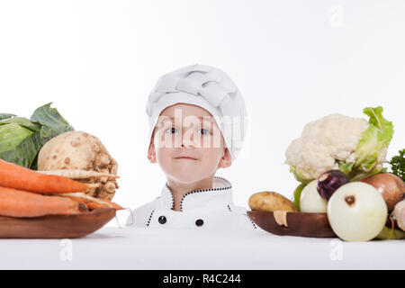 One little boy as chef cook making salad, cooking with vegetables. Isolated on white. Stock Photo