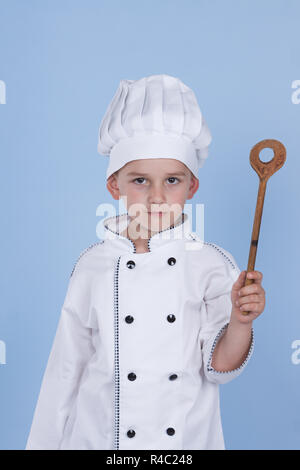 One little boy as chef cook making salad, cooking with vegetables. Isolated on white. Stock Photo