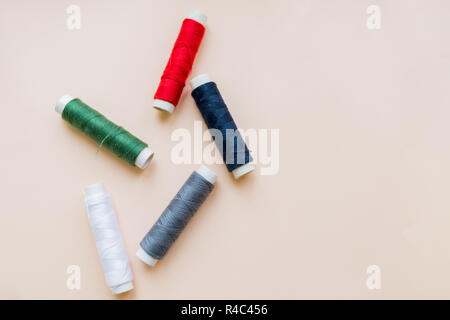 collection of various sewing threads on pastel background. each one is shot separately. knittinng tools.Natural cotton string roll isolated, copy space.Colored thread coils multi colored embroidery thread yarns. Stock Photo