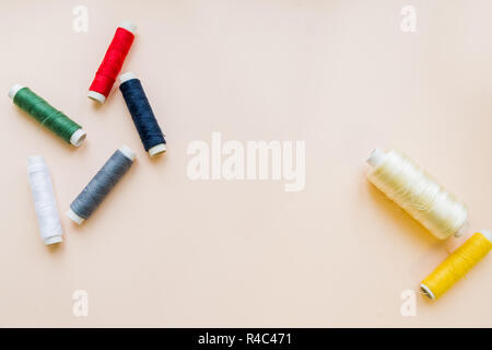 Hanks of multi-coloured threads for embroidery on pastel background.multi colored embroidery thread yarns. Flat lay of colored thread rolls for sewing, Sewing and needlework concept.Copy space Stock Photo