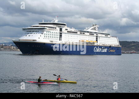 Two young men kayaking in front of cruise ship. Stock Photo
