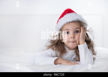 Christmas time, little girl in Santa Claus hat smilling. Stock Photo