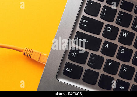 Ethernet LAN cable plugged into laptop computer, top view Stock Photo