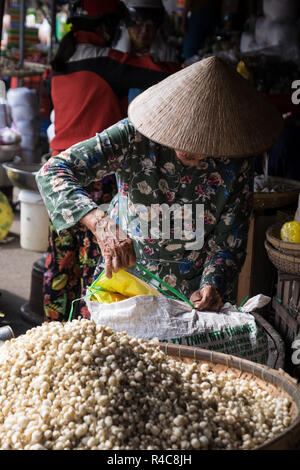An elderly woman wearing a rice hat working at Dong Ba Market in Hue, Vietnam Stock Photo
