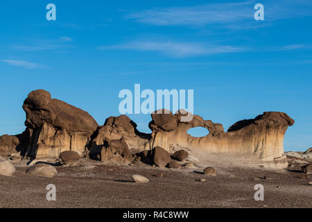Unusual sculpted rock formation with natural window under a blue sky in the Bisti Badlands of New Mexico Stock Photo
