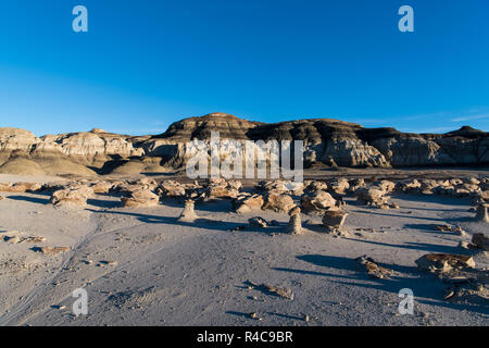 Late afternoon sunlight on the 'Cracked Eggs' rock field and rock formations in the Bisti Badlands in New Mexico Stock Photo
