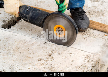 Close up worker cuts concrete with circular saw Stock Photo