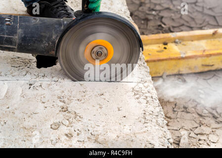 Close up worker cuts concrete with circular saw Stock Photo