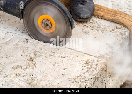Close up worker cuts concrete with circular saw Stock Photo