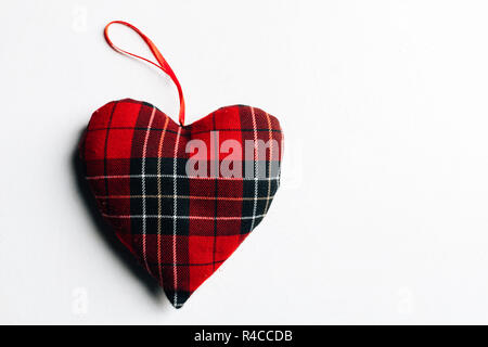 The checkered red fabric heart in the middle,free space for texts isolated on white background.Concept St Valentine Stock Photo