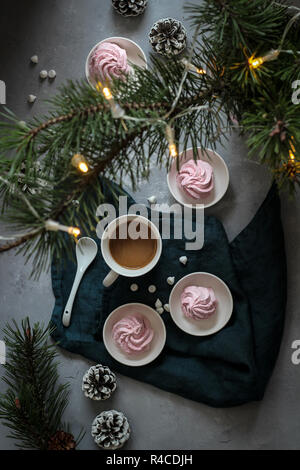 Coffee cup with marshmallows with pine branch and lights, dark mood Stock Photo