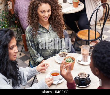 Content beautiful woman talking with friends in a cafe courtyard Stock Photo