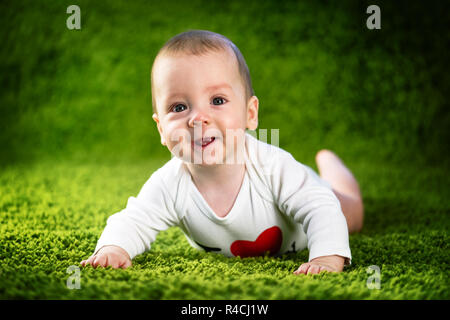 Newborn baby boy portrait on green carpet closeup. Motherhood and new life concept Stock Photo