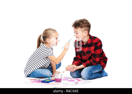 Brother and sister having fun painting with watercolors. Happy creative children at art class. Art therapy concept on white background. Stock Photo