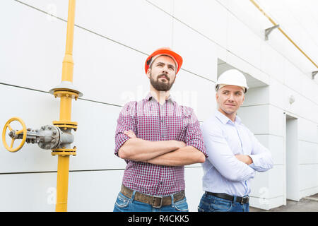 two male engineers in helmets on the building background Stock Photo