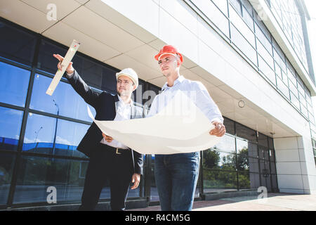 View of an Engineer and worker checking plan on construction site Stock Photo