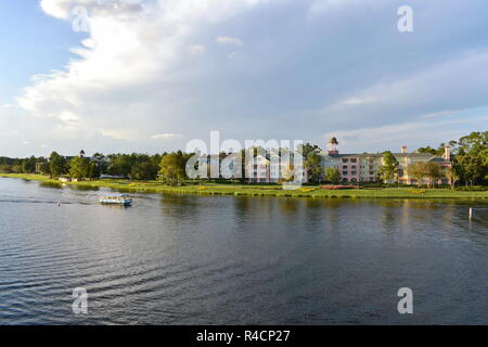 Orlando, Florida. November 18, 2018 Colorful Victorian style Hotel and Taxi Boat on beautiful cloudy sunset background at Lake Buena Vista Stock Photo