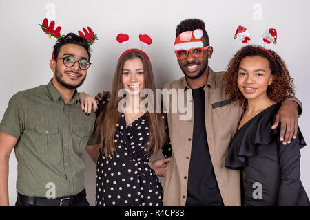 Four friends in funny New Year accessories. Stock Photo