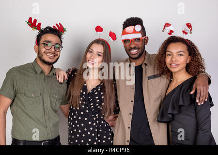 Four friends in funny New Year accessories. Stock Photo