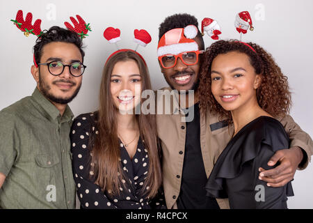 Four friends in funny New Year accessories. Stock Photo