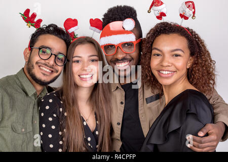 Four friends in funny New Year accessories. Stock Photo