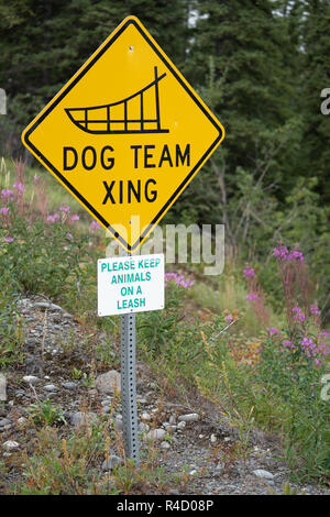 Dog Team Xing - Dog Sled team crossing road sign in Alaska - Portrait view Stock Photo