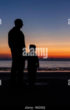 Sculptures of families on the seafront at Colwyn Bay at dawn, North Wales Stock Photo