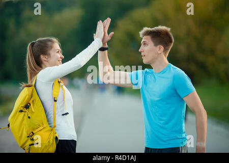 Picture of young women and men doing handshake in park on summer day.Defocused background. Stock Photo