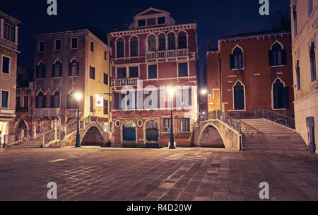 Night view from Venice a couple sitting under street light next to a bridge Stock Photo