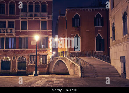 Night view from Venice a couple sitting under street light next to a bridge Stock Photo