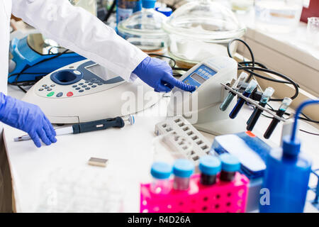 Young female scientist works in modern chemistry/biology lab (shallow DOF  color toned image) Stock Photo