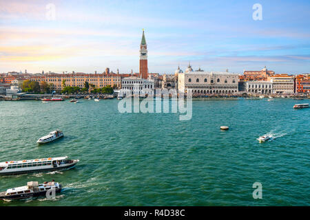Venice, Italy - September 23 2018: A crowded San Marco Square, Campanile, Doge's Palace and St. Mark's Cathedral seen from the sea as boats glide the Stock Photo