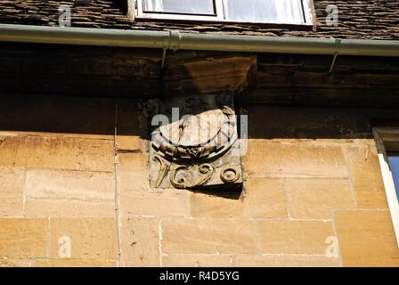 Wall mounted carved sun dial on the wall of a Cotswold stone building in the market town of Chipping Campden, Cotswolds, Gloucestershire, UK Stock Photo