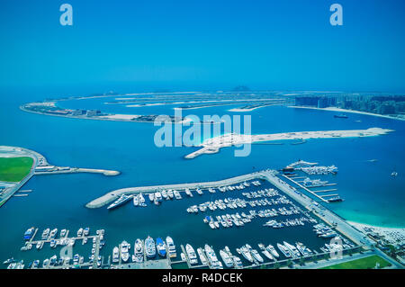 Aerial view of Palm Jumeirah Island with luxury yachts in the front. Development of Dubai. Stock Photo