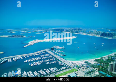 Aerial view of Palm Jumeirah Island with luxury yachts in the front. Development of Dubai. Stock Photo