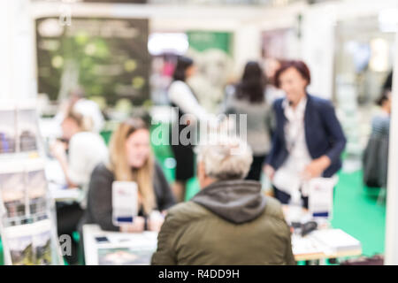 Anonymous blurred people discussing business at a trade fair. Stock Photo