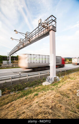 truck passing through a toll gate on a highway (motion blurred image  color toned image) Stock Photo